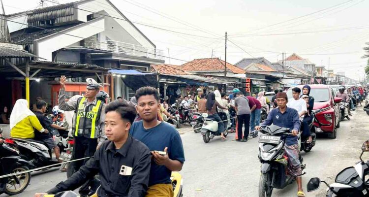Petugas polisi mengatur lalu lintas saat tradisi Per-Peran di Desa Bandaran, Kecamatan Tlanakan, Kabupaten Pamekasan.