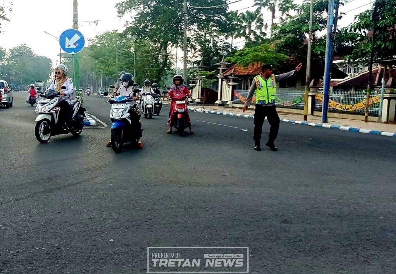 Personel Polres Pamekasan mengatur lalu lintas dan membantu pelajar menyeberang