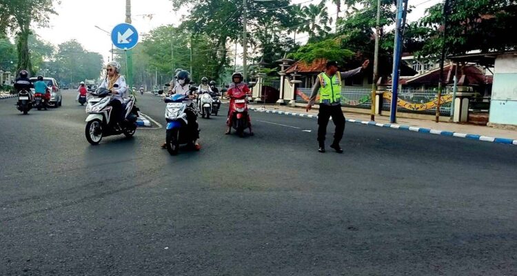 Personel Polres Pamekasan mengatur lalu lintas dan membantu pelajar menyeberang