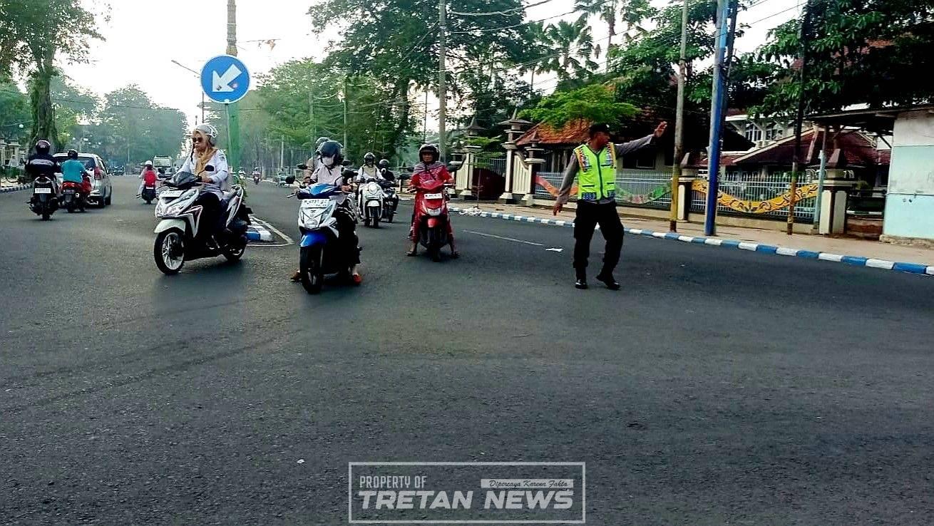 Personel Polres Pamekasan mengatur lalu lintas dan membantu pelajar menyeberang