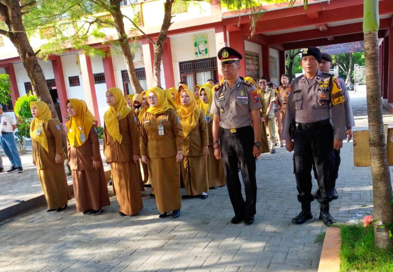 Personel Polres Pamekasan memimpin upacara bersama guru dalam program Polisi Masuk Sekolah di lingkungan sekolah