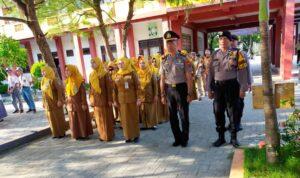 Personel Polres Pamekasan memimpin upacara bersama guru dalam program Polisi Masuk Sekolah di lingkungan sekolah