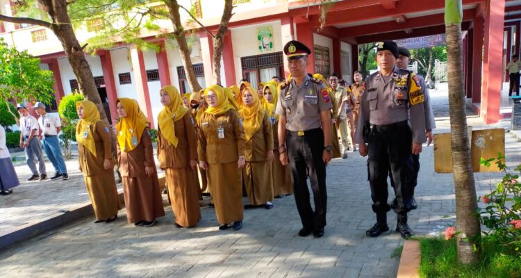 Personel Polres Pamekasan memimpin upacara bersama guru dalam program Polisi Masuk Sekolah di lingkungan sekolah