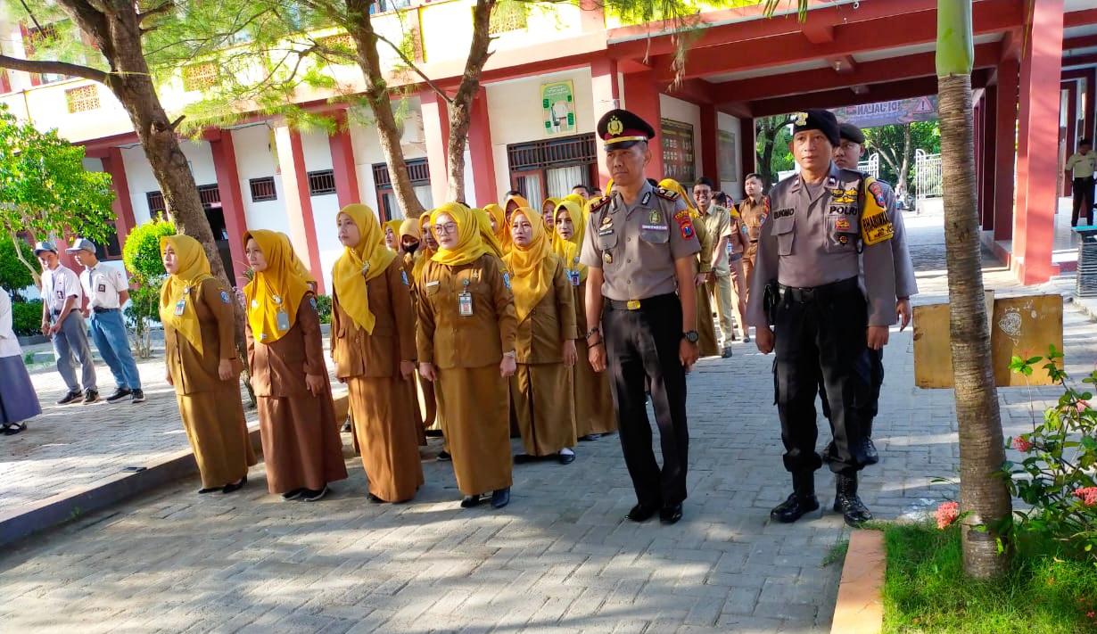 Personel Polres Pamekasan memimpin upacara bersama guru dalam program Polisi Masuk Sekolah di lingkungan sekolah