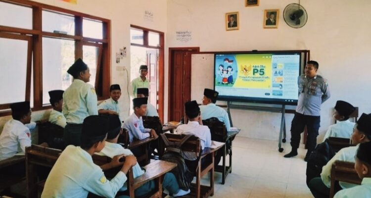 Personel Polres Pamekasan berinteraksi dengan santri di kelas saat edukasi tentang bahaya narkoba dan etika lalu lintas dalam program Police Goes to Pesantren