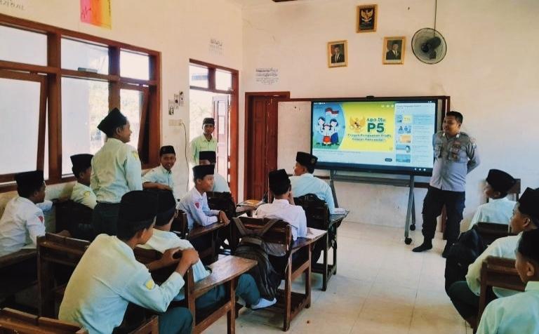 Personel Polres Pamekasan berinteraksi dengan santri di kelas saat edukasi tentang bahaya narkoba dan etika lalu lintas dalam program Police Goes to Pesantren