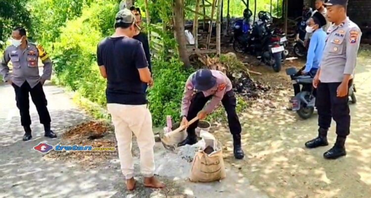 Polres Pamekasan bersama warga mengaduk semen saat gotong royong pembangunan jembatan desa di Proppo untuk akses sekolah dan ekonomi